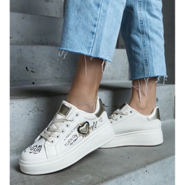 Beigefarbene Sneakers, verziert mit einem Aufnäher und Aufschriften auf der Etara-Plattform 1