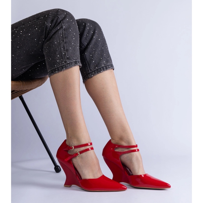 Rote Pumpen, die auf Keil mit Schnallen lackiert sind 2