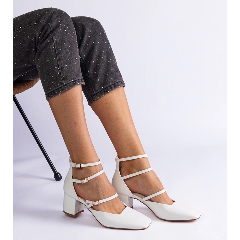 Weiße Pumpen auf der Säule mit Schnallen 1