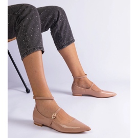 Beige Pumpen, die mit flachen Absätzen mit beige Schnallen lackiert sind 1