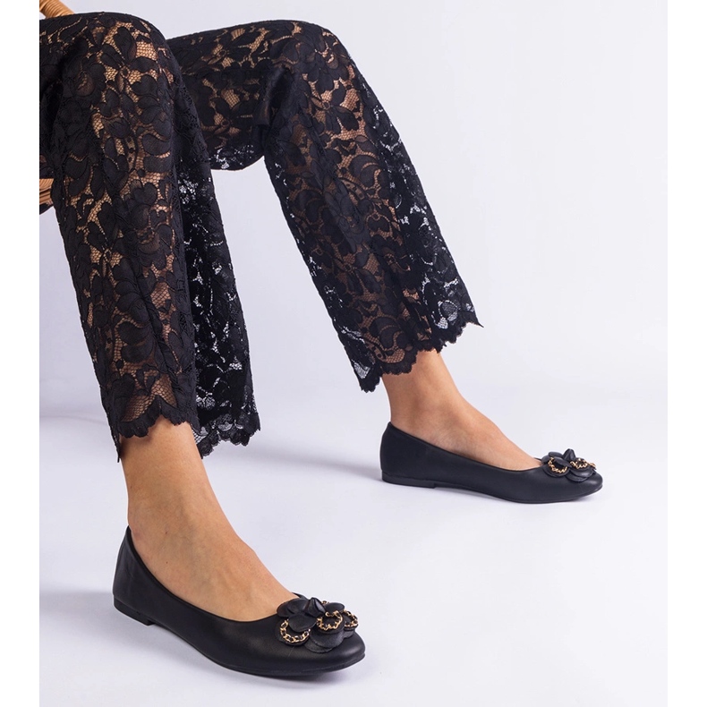 Schwarze Ballerinas mit einer Blume dekoriert 1