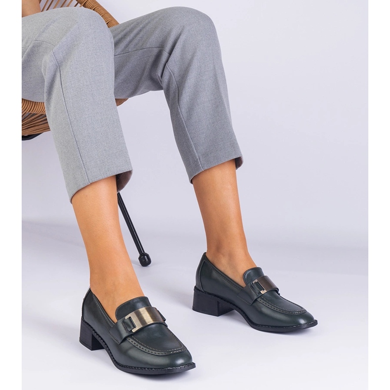 Grüne Schuhe auf einem niedrigen Pfosten mit einer metallischen Dekoration 1