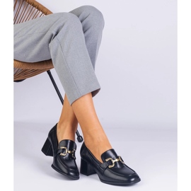 Schwarze Pumpen auf dem Pfosten mit einer metallischen Dekoration 1