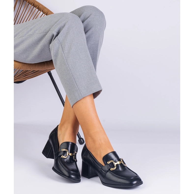 Schwarze Pumpen auf dem Pfosten mit einer metallischen Dekoration 1