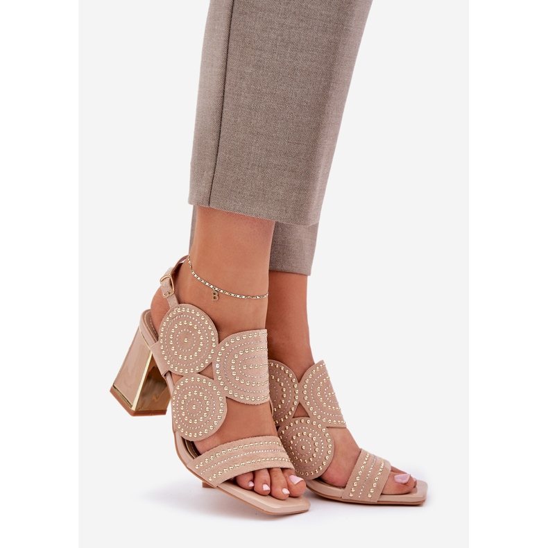 Dekorierte Sandalen auf dem dunklen Pfosten beige 1