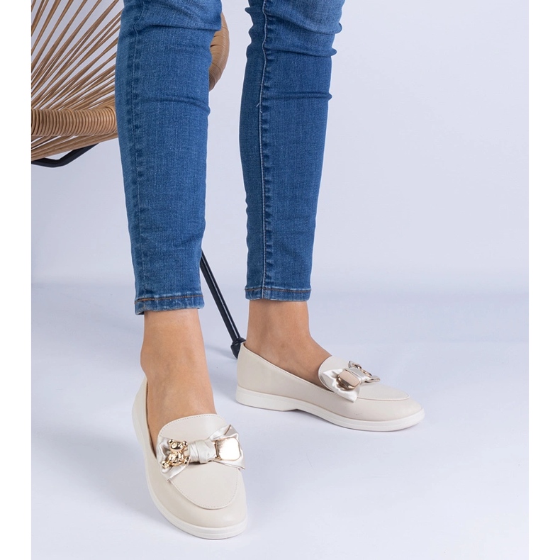 Beige -Slipper mit einem Bug und einem goldenen Teddybär dekoriert 1