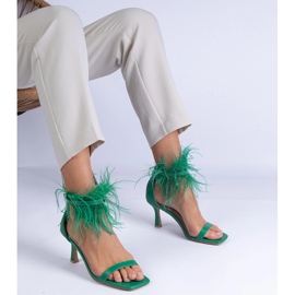 Grüne Sandalen auf einem Stift mit Federn 3