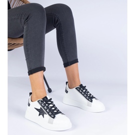 Weiße Turnschuhe mit einem Glitzerstern dekoriert 1