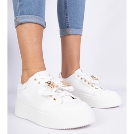 Weiße Turnschuhe mit einem Bug und einem goldenen Teddybär dekoriert 1