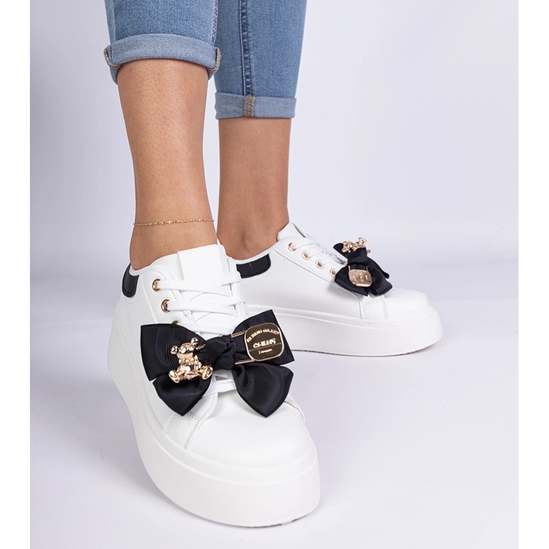 Schwarze Turnschuhe mit einem Bug und einem goldenen Teddybär dekoriert 1