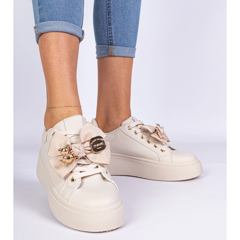 Beige Sneakers mit einem Bug und einem goldenen Teddybär dekoriert 2