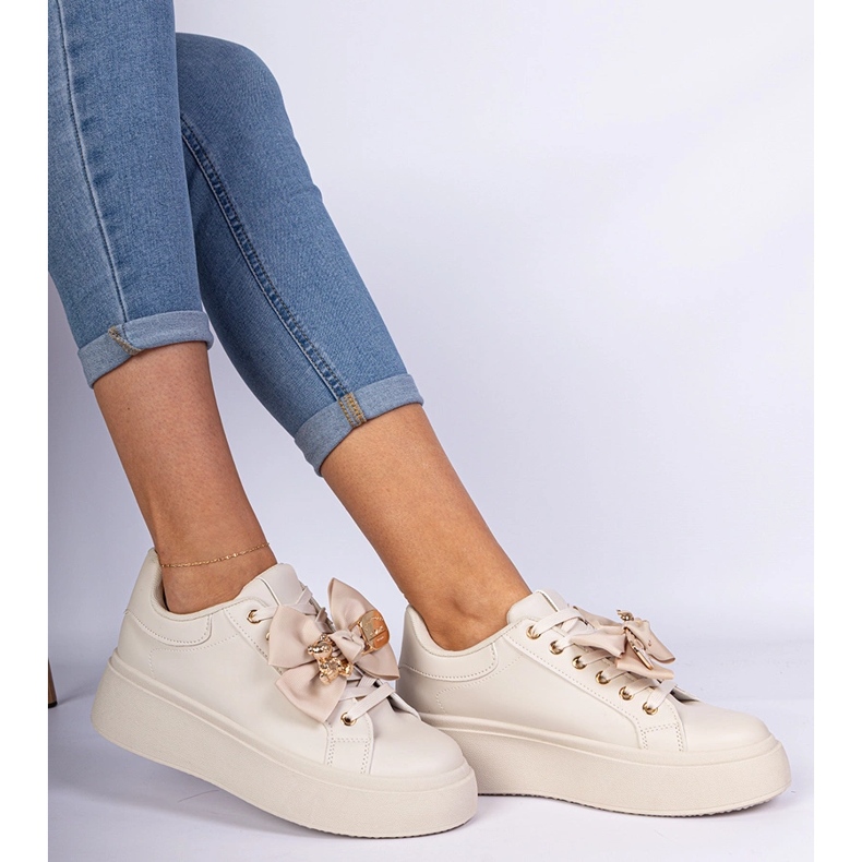 Beige Sneakers mit einem Bug und einem goldenen Teddybär dekoriert 1