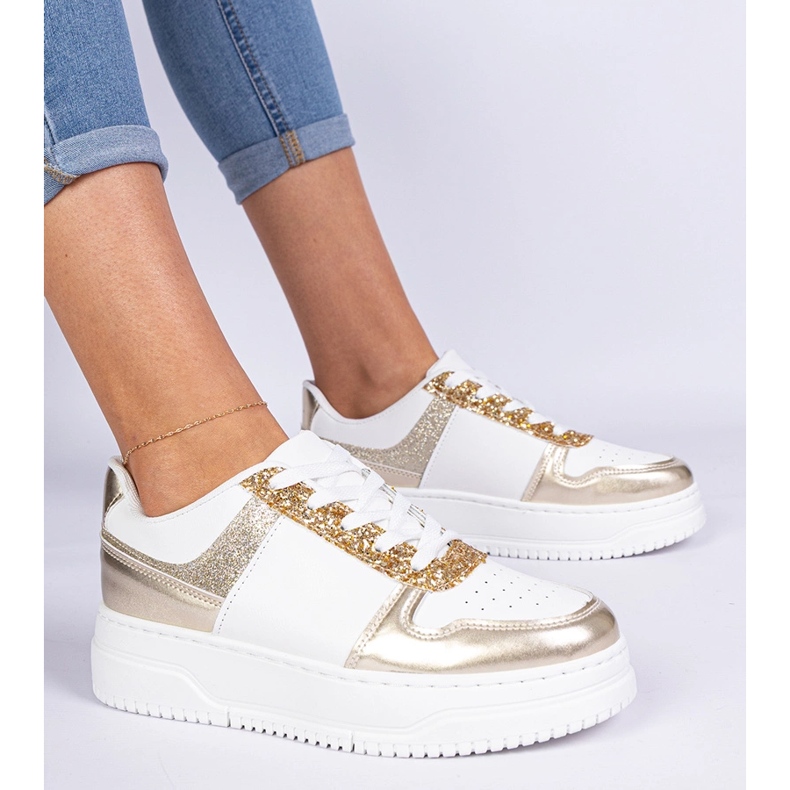 Goldene Frauen -Turnschuhe auf einer dicken Sohle mit Glitzer dekoriert 2