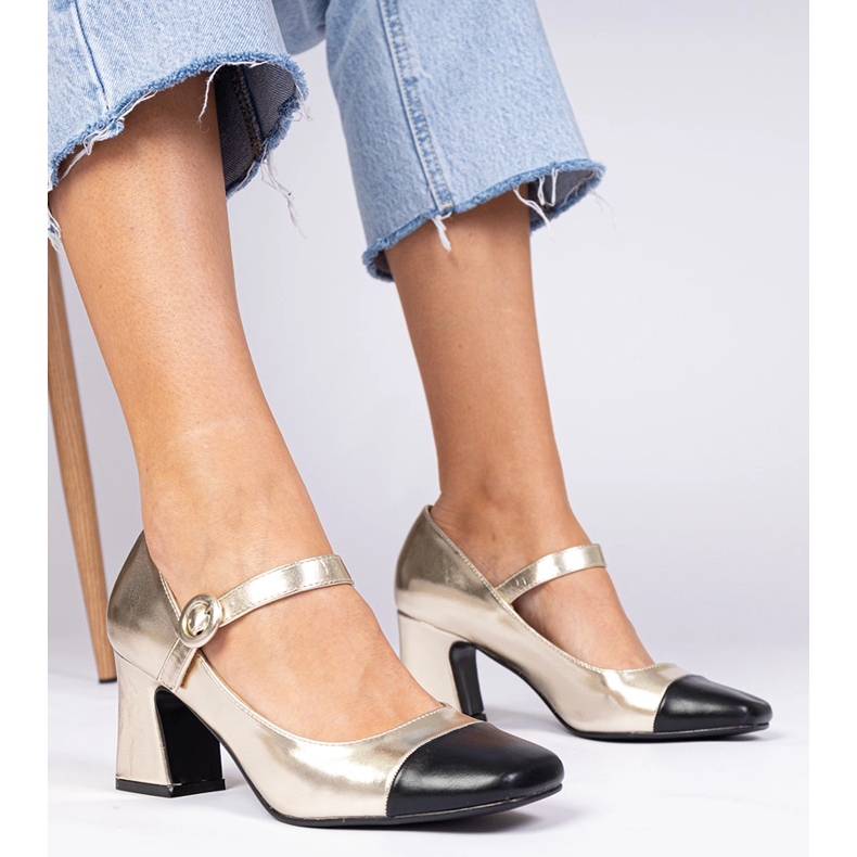 Goldene Frauenpumpen mit einer schwarzen Nase 1