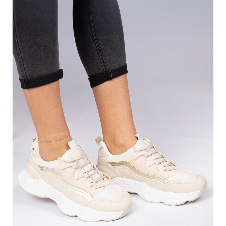 Beige Frauen -Sneakers mit einer goldenen Ergänzung 1