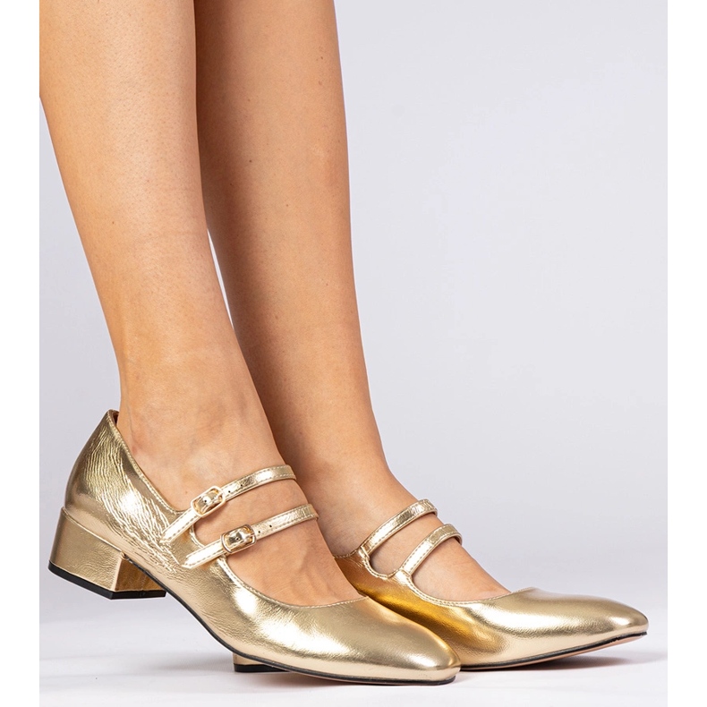 Goldene Frauenpumpen auf der Säule mit Schnallen 1
