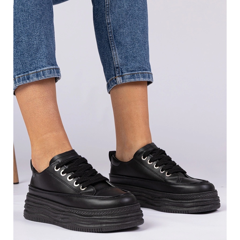 Schwarze Frauen -Turnschuhe auf einer hohen Sohle 1