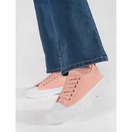 Klassische Turnschuhe auf der hellrosa Plattform 1