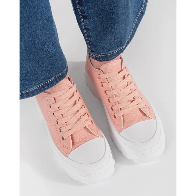 Klassische Turnschuhe auf der hellrosa Plattform 2