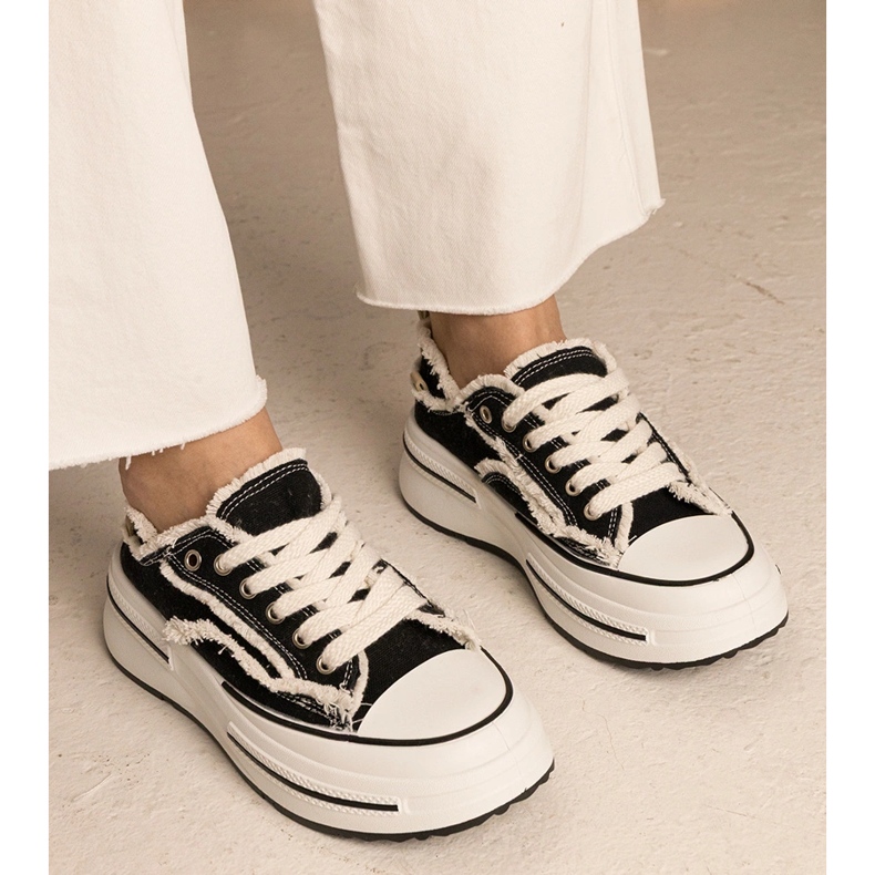 Schwarze Frauen -Turnschuhe auf einer hohen Sohle 1