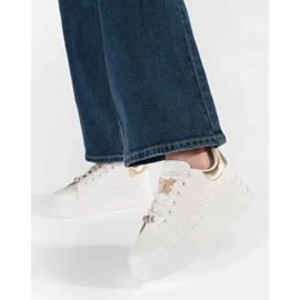 Weiße Turnschuhe auf der Plattform mit Pin 1