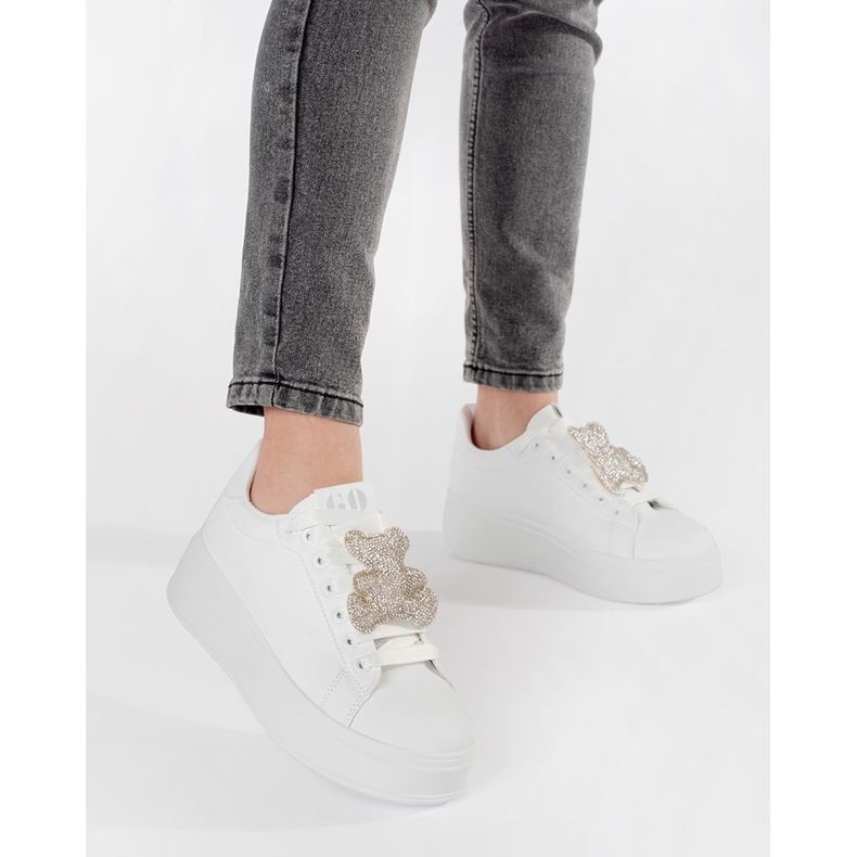 Weiße Turnschuhe auf einer Teddybären -Plattform 2