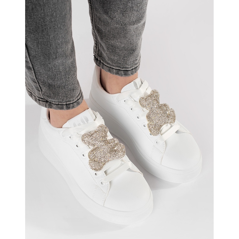 Weiße Turnschuhe auf einer Teddybären -Plattform 1