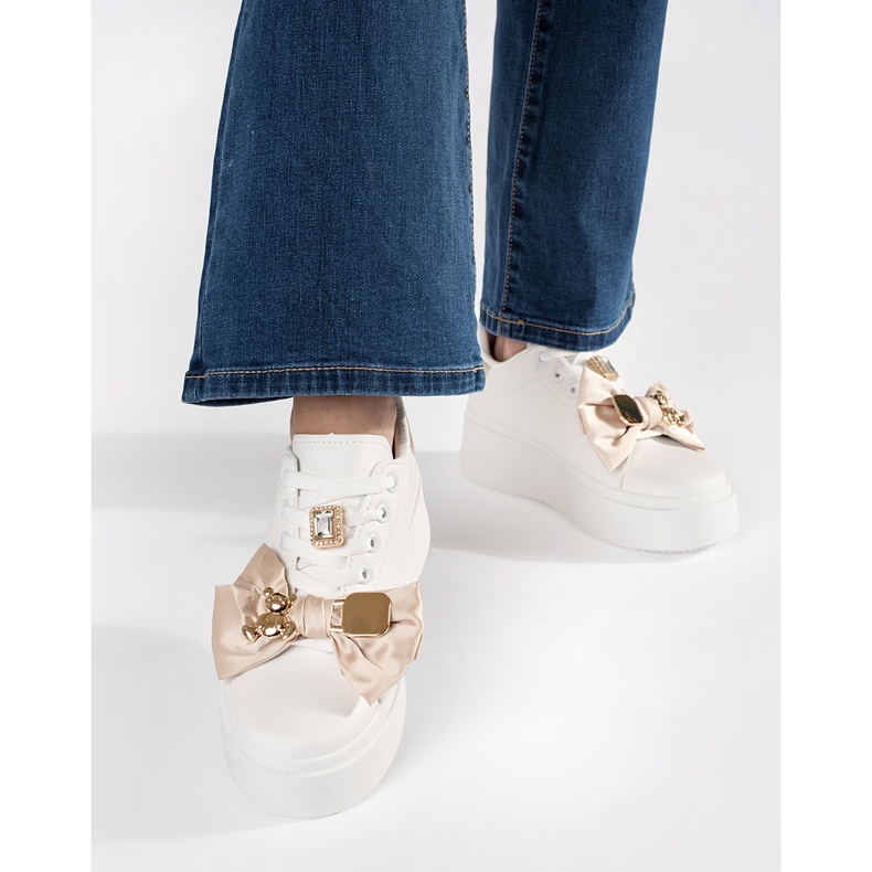 Weiße und goldene Turnschuhe mit goldenen Ergänzungen 2