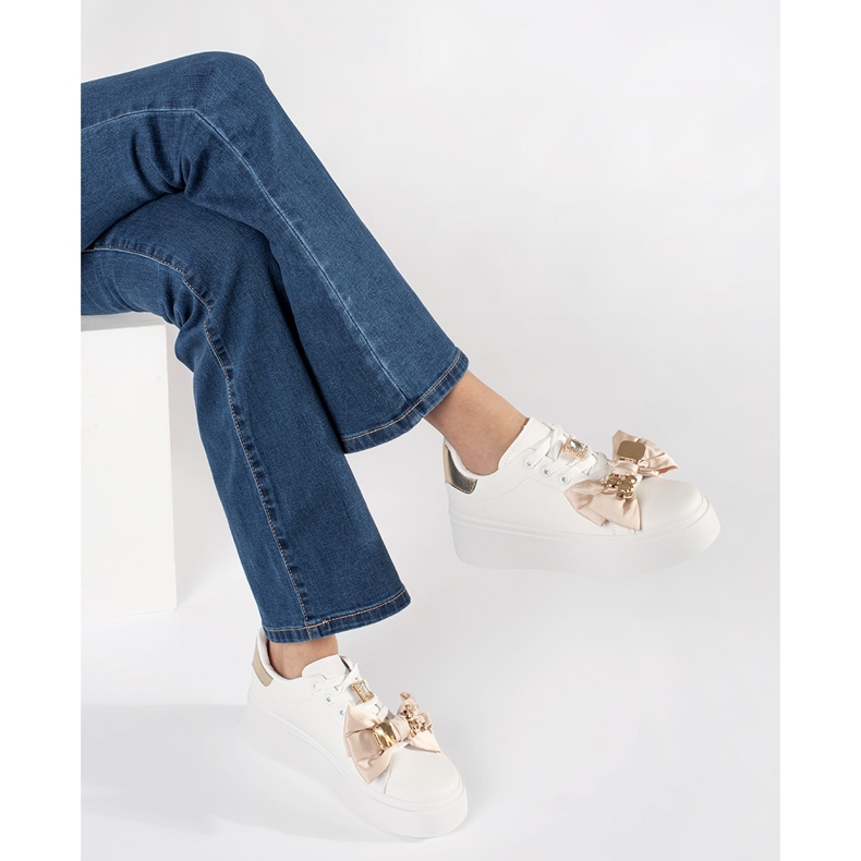 Weiße und goldene Turnschuhe mit goldenen Ergänzungen 1