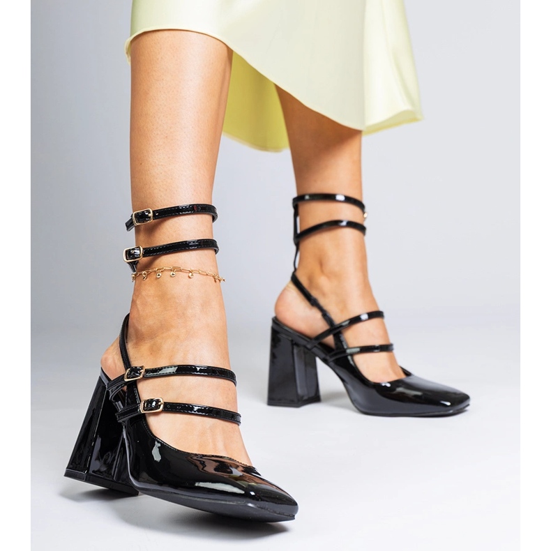 Schwarze Sandalen lackiert auf dem Pfosten 1