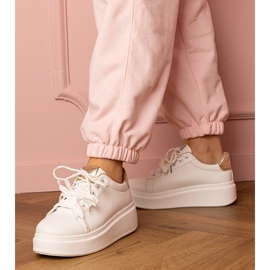 Weiße und goldene Sport -Turnschuhe auf der Plattform 1