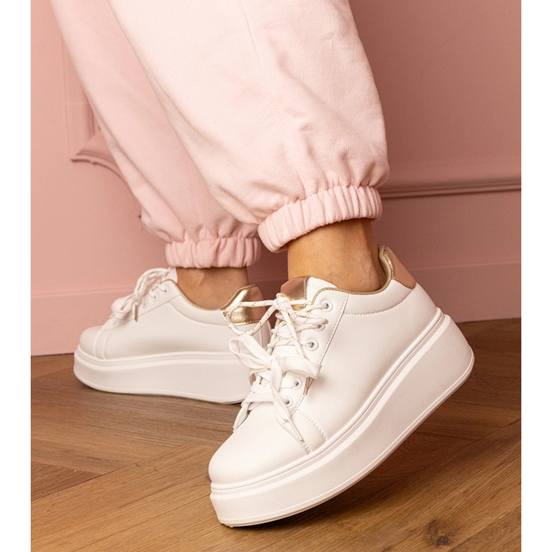 Weiße und goldene Sport -Turnschuhe auf der Plattform 2