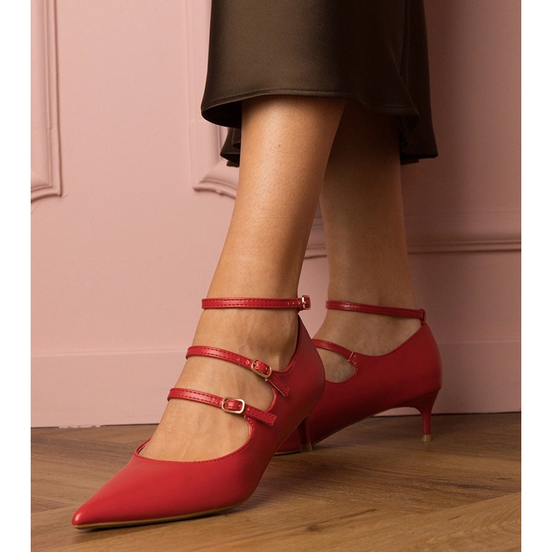 Rote Pumpen auf einem niedrigen Stapel mit Schnallen 1