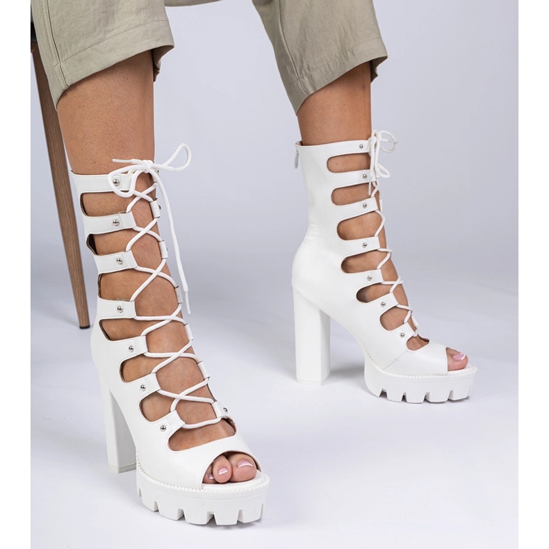 Weiße Stiefel auf einer hohen Säule mit Ausschnitten 1