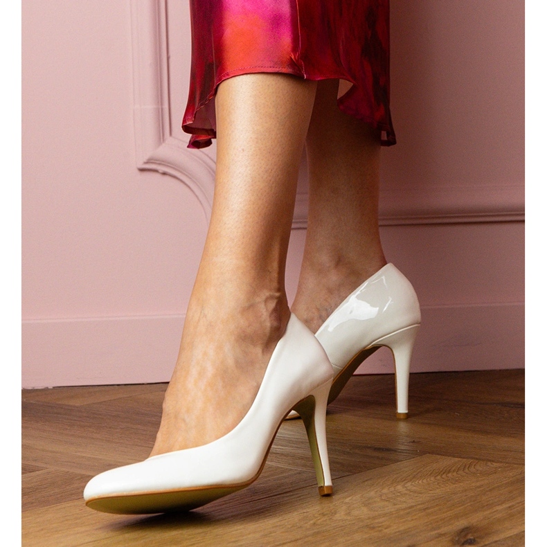 Weiße klassische Pumpen, die auf einem Stift lackiert sind 1