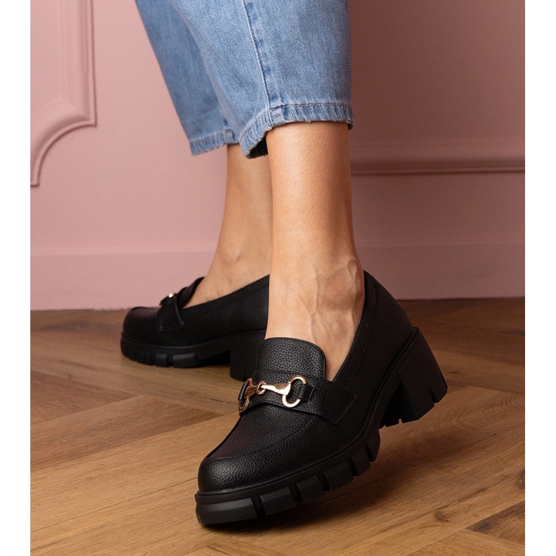 Schwarze Schuhe auf einem niedrigen Pfosten mit einer goldenen Dekoration 1