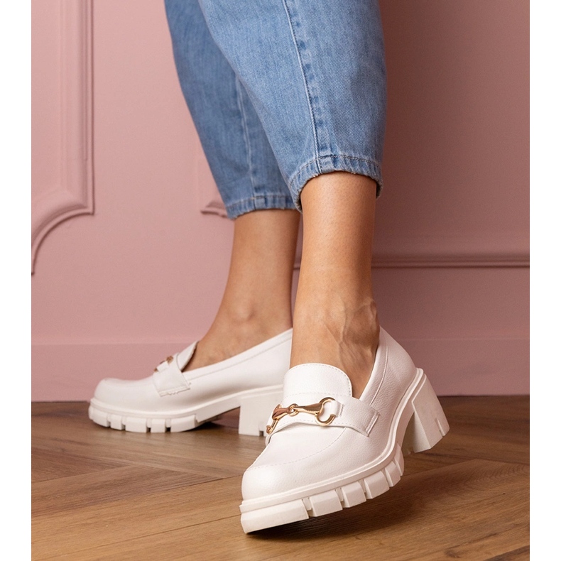 Weiße Schuhe auf einem niedrigen Pfosten mit einer goldenen Verzierung 1