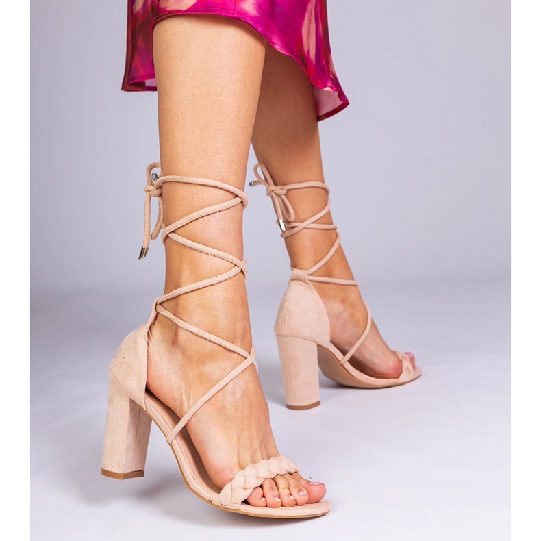 Beige Sandalen, die am Pfosten gebunden sind 1