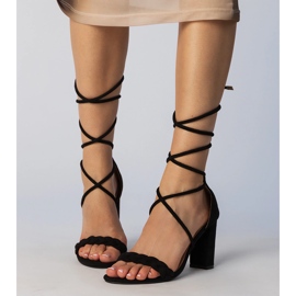 Schwarze Sandalen, die am gebundenen Pfosten gebunden sind 3