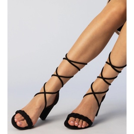Schwarze Sandalen, die am gebundenen Pfosten gebunden sind 1