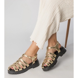 Goldsandalen auf der Plattform mit einer Fingerlinie gebaut golden 1