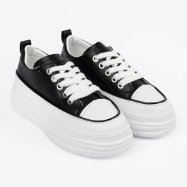 Schwarze und weiße Turnschuhe auf der Plattform 4