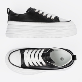 Schwarze und weiße Turnschuhe auf der Plattform 5