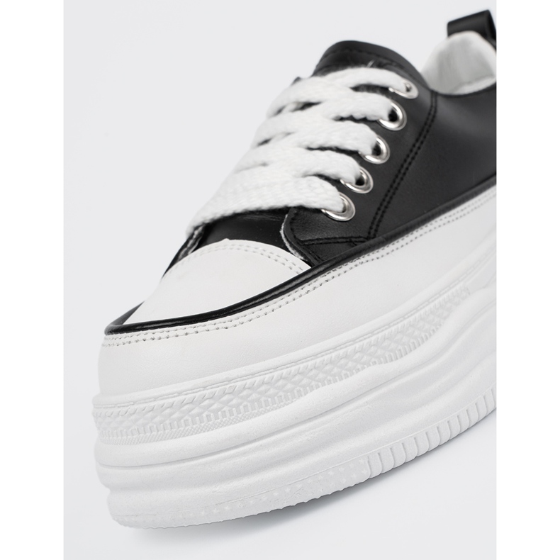 Schwarze und weiße Turnschuhe auf der Plattform 1