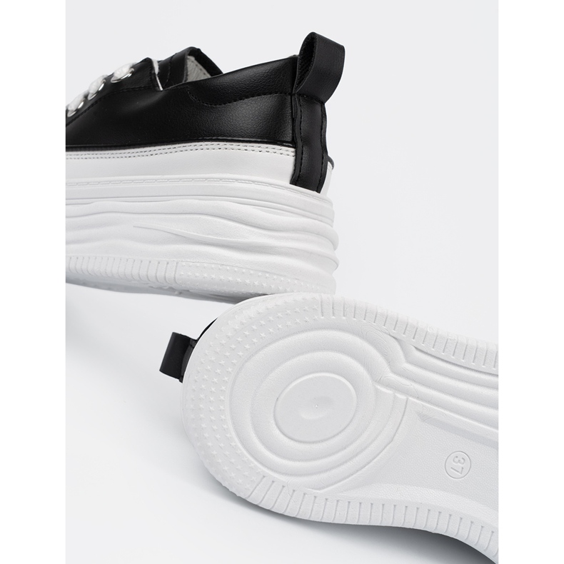 Schwarze und weiße Turnschuhe auf der Plattform 2