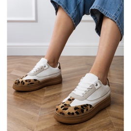 Weiße Turnschuhe mit einem Leopardenzubehör 1