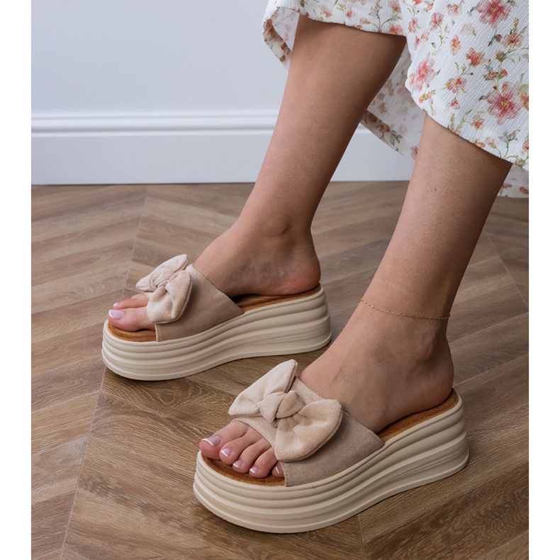 Braune Flip Flops auf der Plattform mit einem Bogen 1