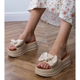 Beige Flip Flops auf der Plattform mit einem Bogen 1