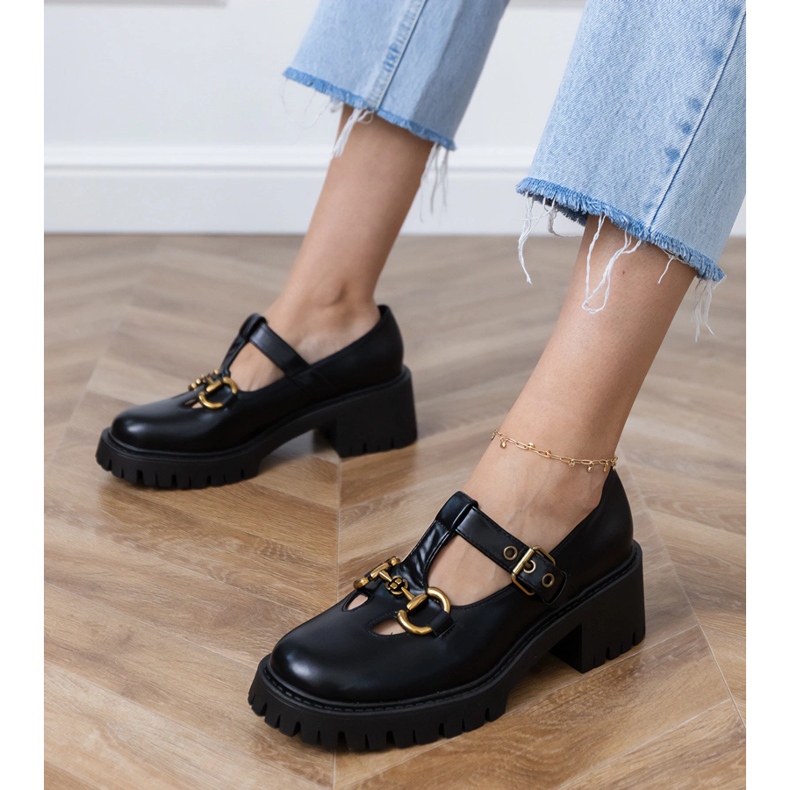 Schwarze Schuhe auf einer dicken Sohle mit goldener Dekoration 1