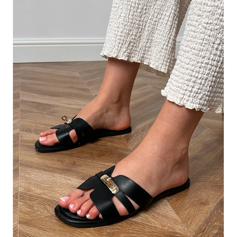 Schwarze Flip -Flops mit Ausschnitten am Gürtel und goldener Dekoration. 1